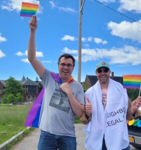 Two NLS team members holding Pride flags