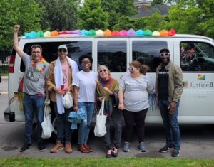 NLS group photo in front of Justice Bus at Pride