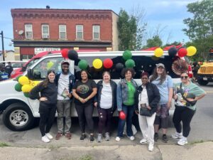 NLS team members standing in front of the Justice Bus, decorated for Juneteenth