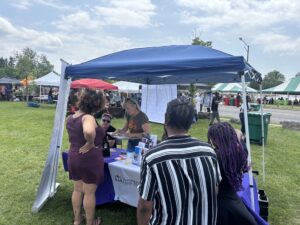 Clients receiving information from NLS team members at outside tabling event.