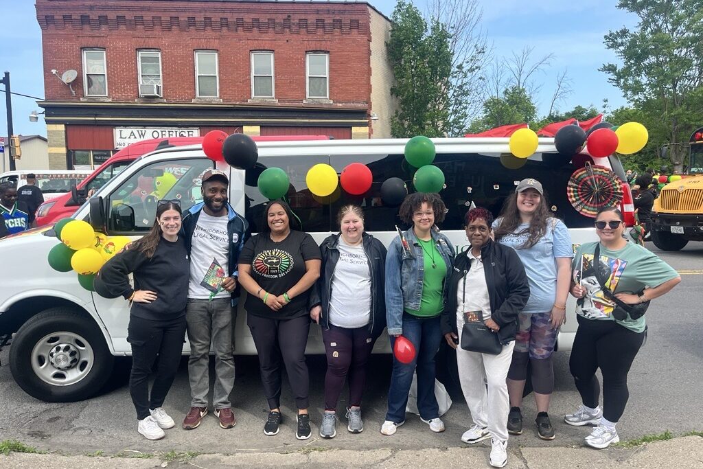 NLS team in front of the Justice Bus at Juneteenth 2025