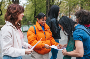 Stock photo of volunteers asking community members to sign a petition.