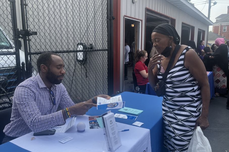 Davewin providing resources to a client at an outdoor tabling event.