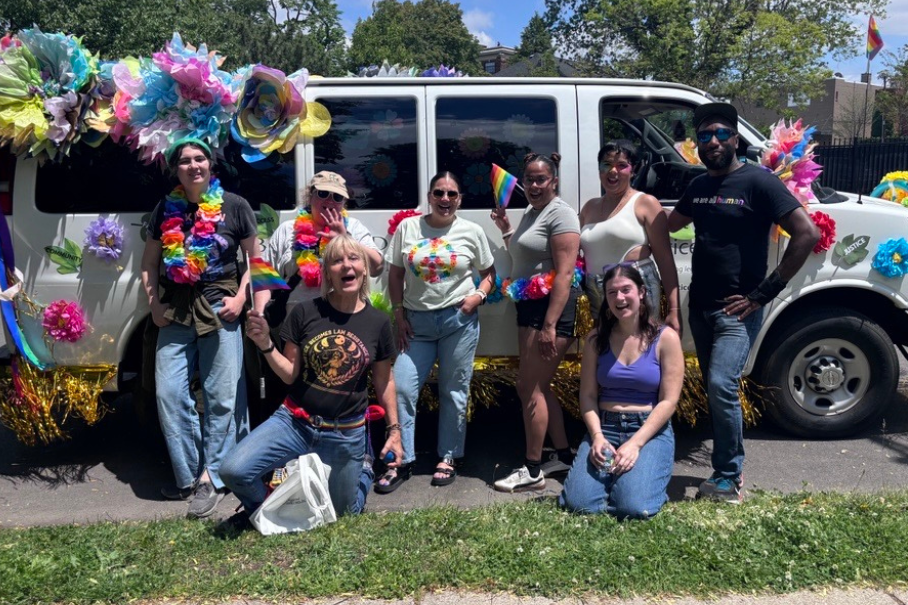 NLS team at the 2026 Pride Parade. Group photo in front of our decorated Justice Bus.
